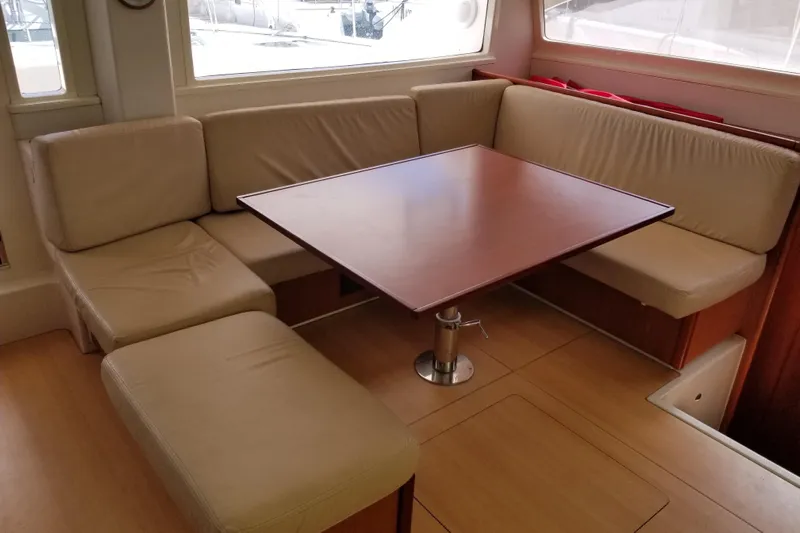 Zumbrota Yacht Photos Pics Luxurious interior of 2014 Leopard 48 yacht with beige seating and wooden table.
