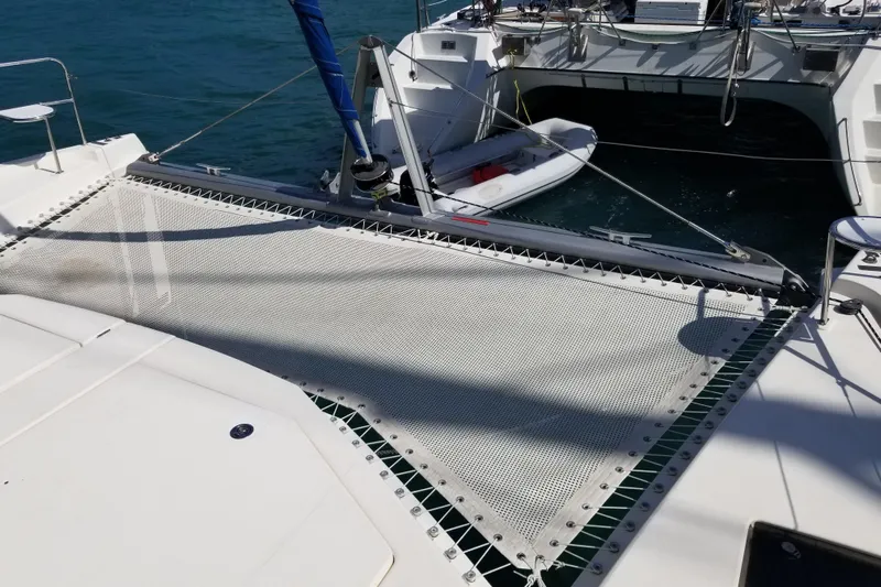 Zumbrota Yacht Photos Pics 2014 Leopard 48 catamaran with netting and dinghy on blue water.
