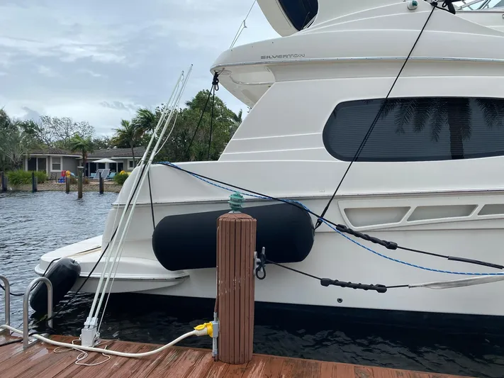 Dazilus Yacht Photos Pics 2001 Silverton 410 Sport Bridge yacht docked by the water.
