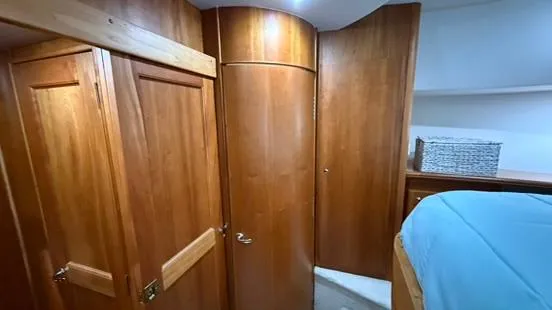 Dazilus Yacht Photos Pics Interior cabin of 2001 Silverton 410 Sport Bridge with wooden cabinetry and blue bedding.