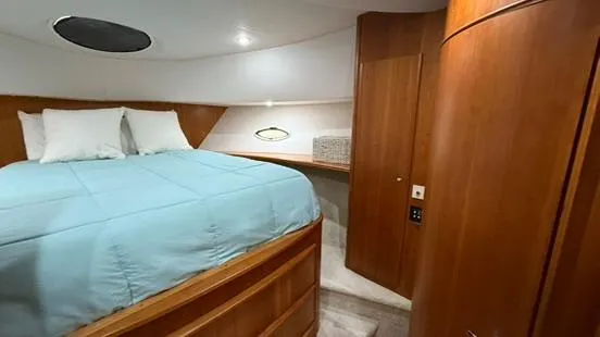 Dazilus Yacht Photos Pics Interior cabin of 2001 Silverton 410 Sport Bridge with bed and wooden cabinetry.