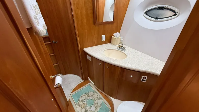 Dazilus Yacht Photos Pics 2001 Silverton 410 Sport Bridge bathroom with wood cabinetry and oval window.