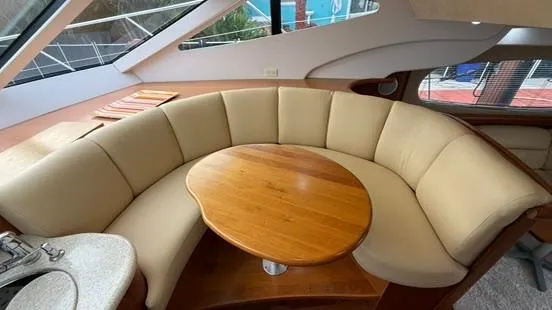 Dazilus Yacht Photos Pics Interior of 2001 Silverton 410 Sport Bridge with curved seating and wooden table.