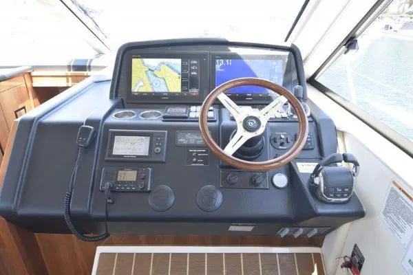 No Contingencies Yacht Photos Pics 2012 Riviera 440 Sport Yacht helm with navigation screens and steering wheel.