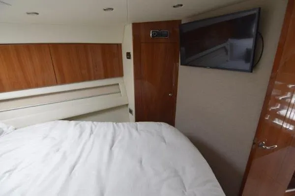 No Contingencies Yacht Photos Pics Interior of 2012 Riviera 440 Sport Yacht bedroom with TV and wooden cabinetry.