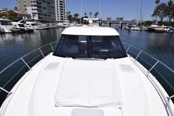 No Contingencies Yacht Photos Pics 2012 Riviera 440 Sport Yacht docked in a marina with surrounding boats and buildings.