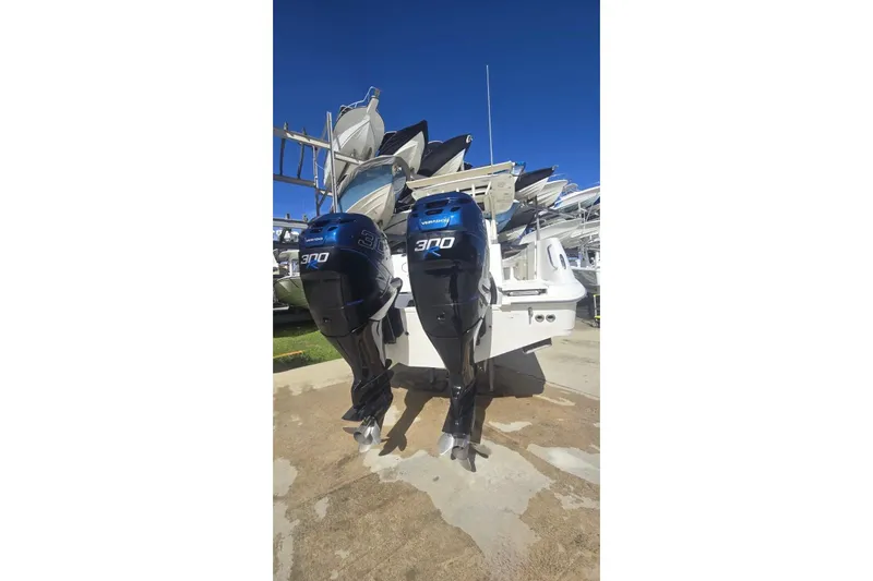  Yacht Photos Pics 2013 Boston Whaler 320 Outrage with twin 300 horsepower engines, docked under clear blue sky.