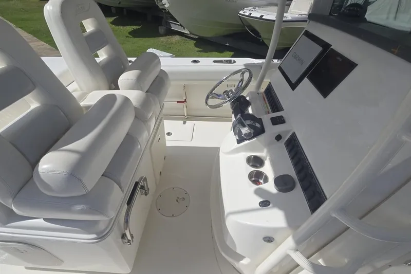 Yacht Photos Pics 2013 Boston Whaler 320 Outrage helm with white seating and navigation controls.