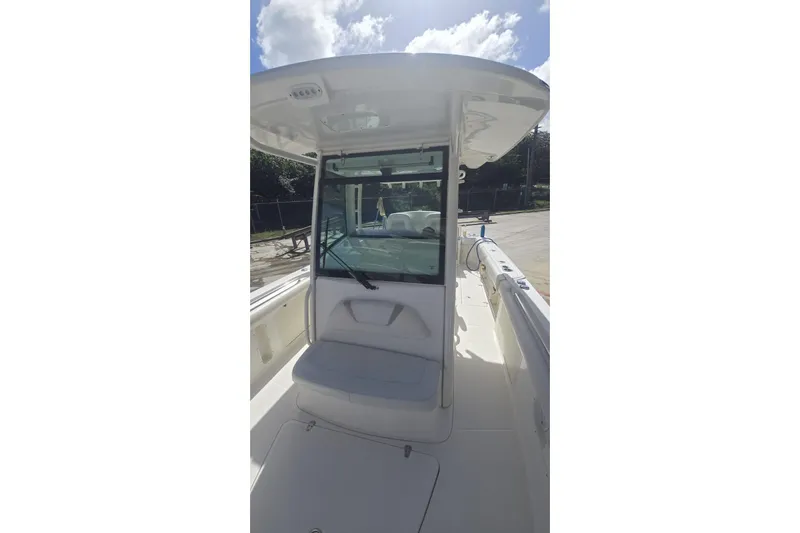  Yacht Photos Pics 2013 Boston Whaler 320 Outrage boat interior with seating and windshield under sunny sky.