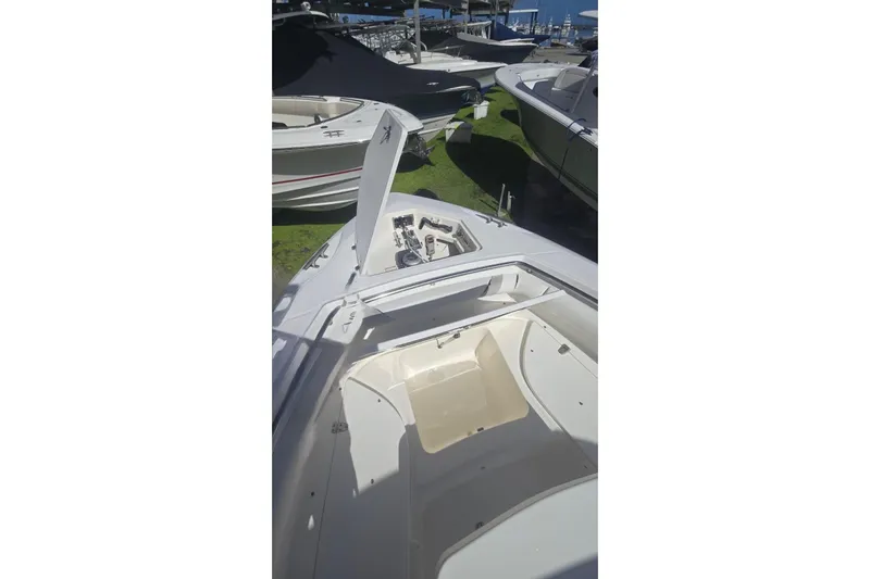  Yacht Photos Pics 2013 Boston Whaler 320 Outrage boat with open storage compartments, docked outdoors.