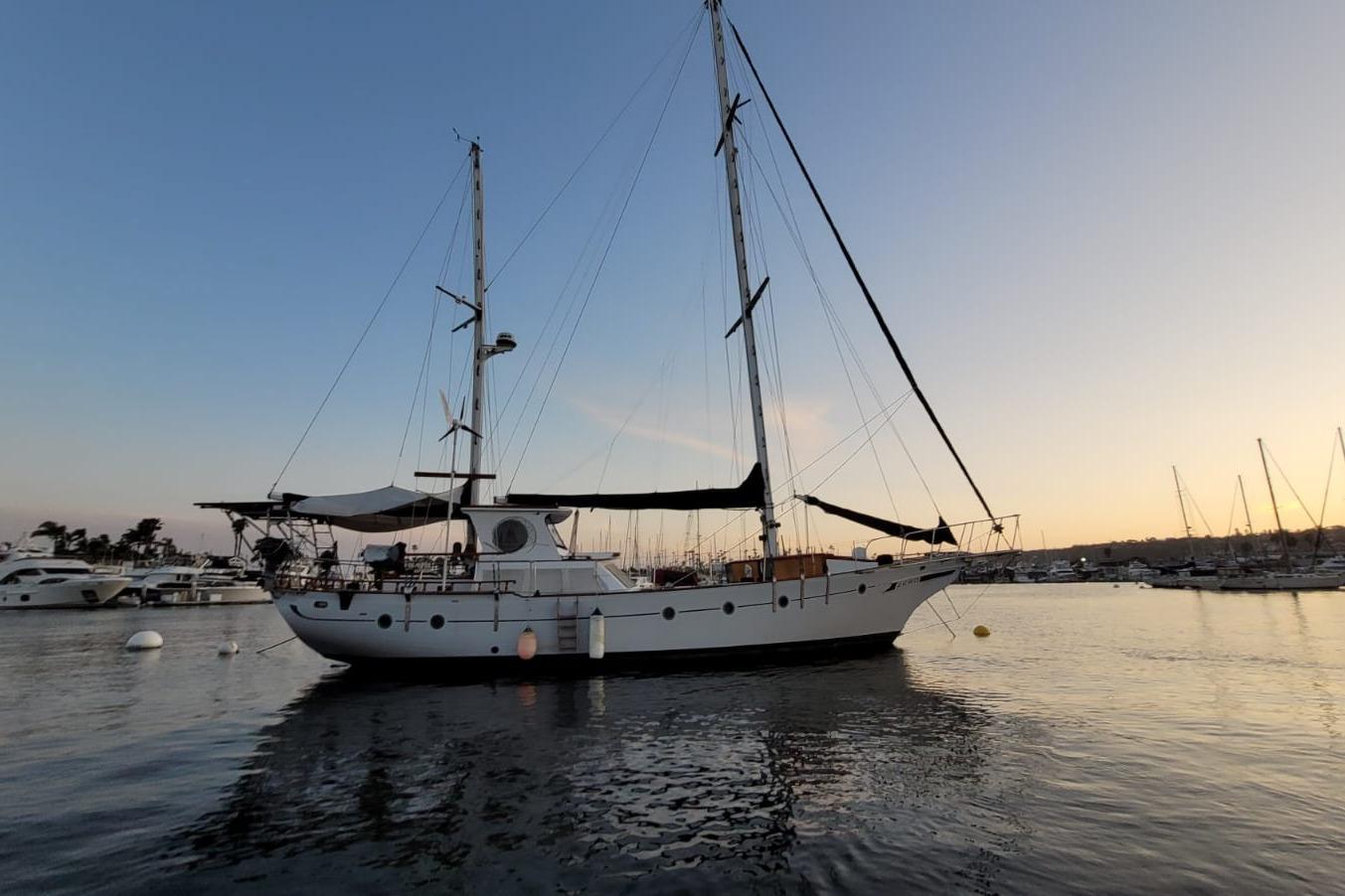 1974 Force Hudson 50 sailboat docked at sunset in a serene marina.