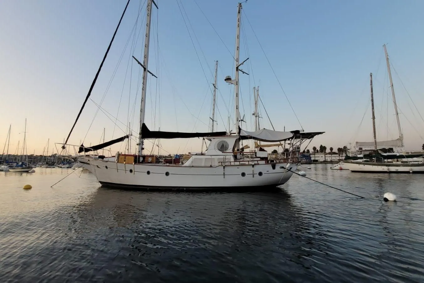 1974 Force Hudson 50 sailboat docked in a serene marina at sunset.