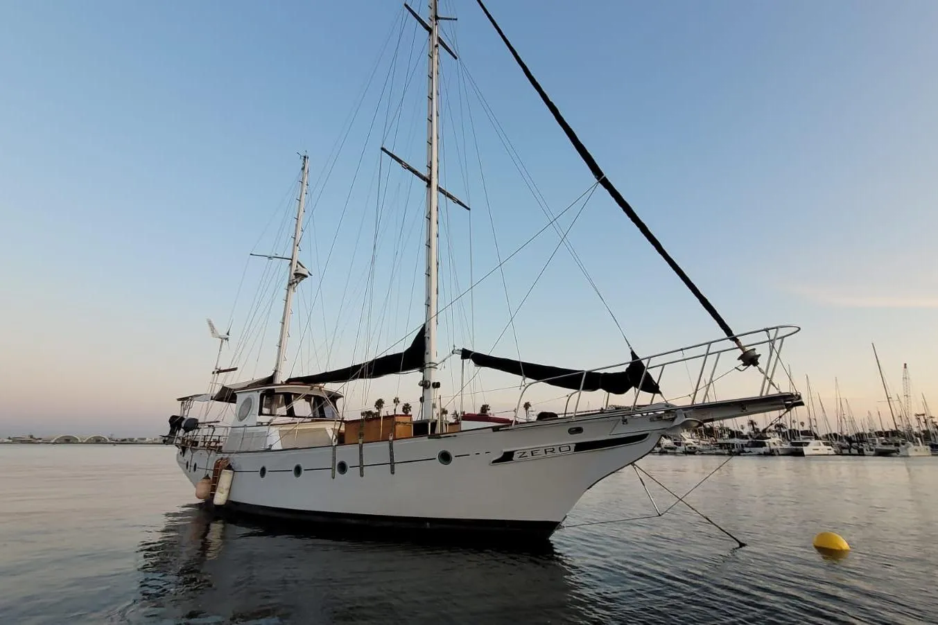 1974 Force Hudson 50 sailboat docked at sunset, featuring two masts and a sleek design.