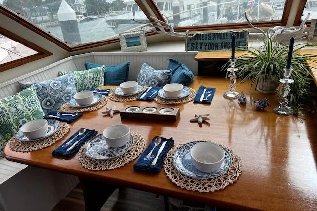  Yacht Photos Pics Elegant dining setup on 1989 Hatteras 70 Cockpit Motor Yacht, featuring nautical-themed decor.