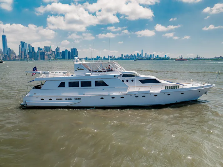 Justine Yacht Photos Pics 1987 Guy Couach 97 yacht cruising near city skyline under blue sky.