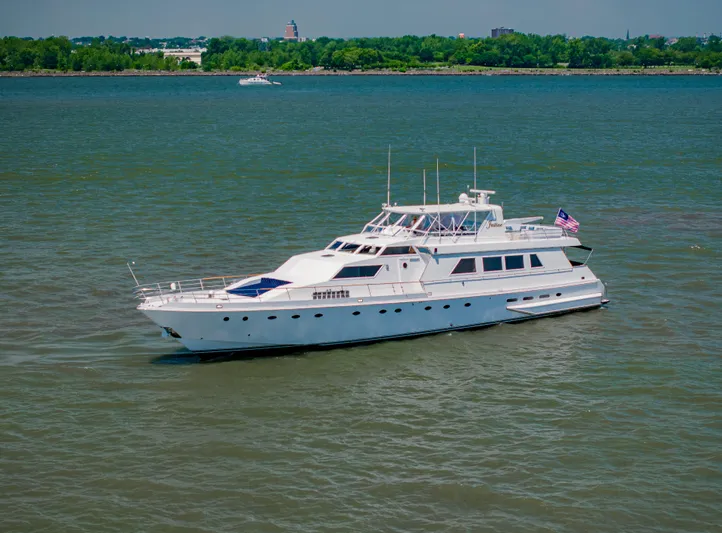 Justine Yacht Photos Pics Luxury 1987 Guy Couach 97 yacht cruising on a calm river.