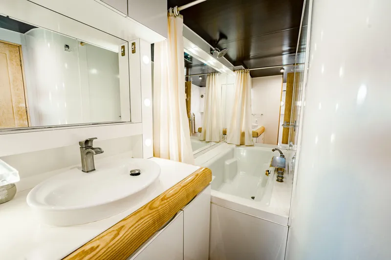 Justine Yacht Photos Pics Luxurious bathroom interior on 1987 Guy Couach 97 yacht, featuring modern sink and bathtub.