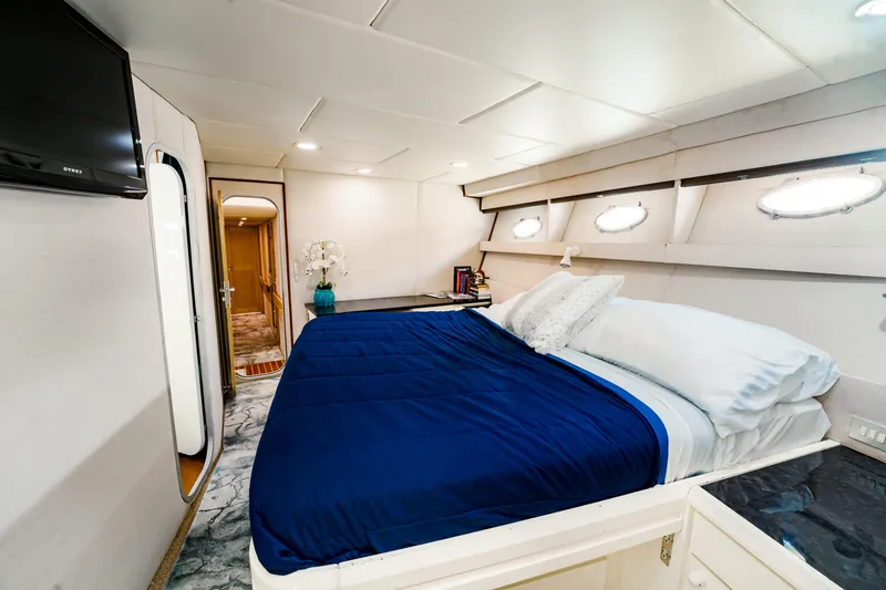 Justine Yacht Photos Pics Luxurious bedroom interior of 1987 Guy Couach 97 yacht with blue bedding and modern decor.