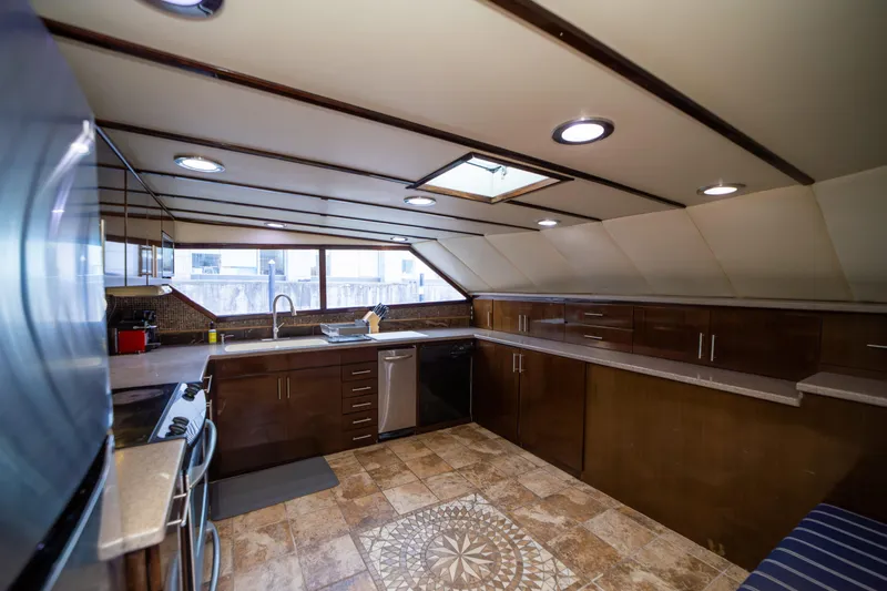 Justine Yacht Photos Pics Luxurious kitchen interior on a 1987 Guy Couach 97 yacht, featuring modern appliances and elegant design.