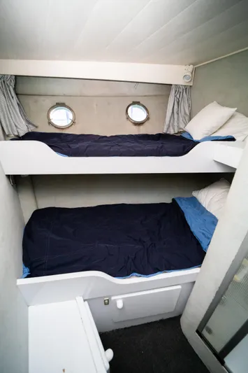 Justine Yacht Photos Pics Bunk beds in 1987 Guy Couach 97 yacht cabin with portholes and blue bedding.