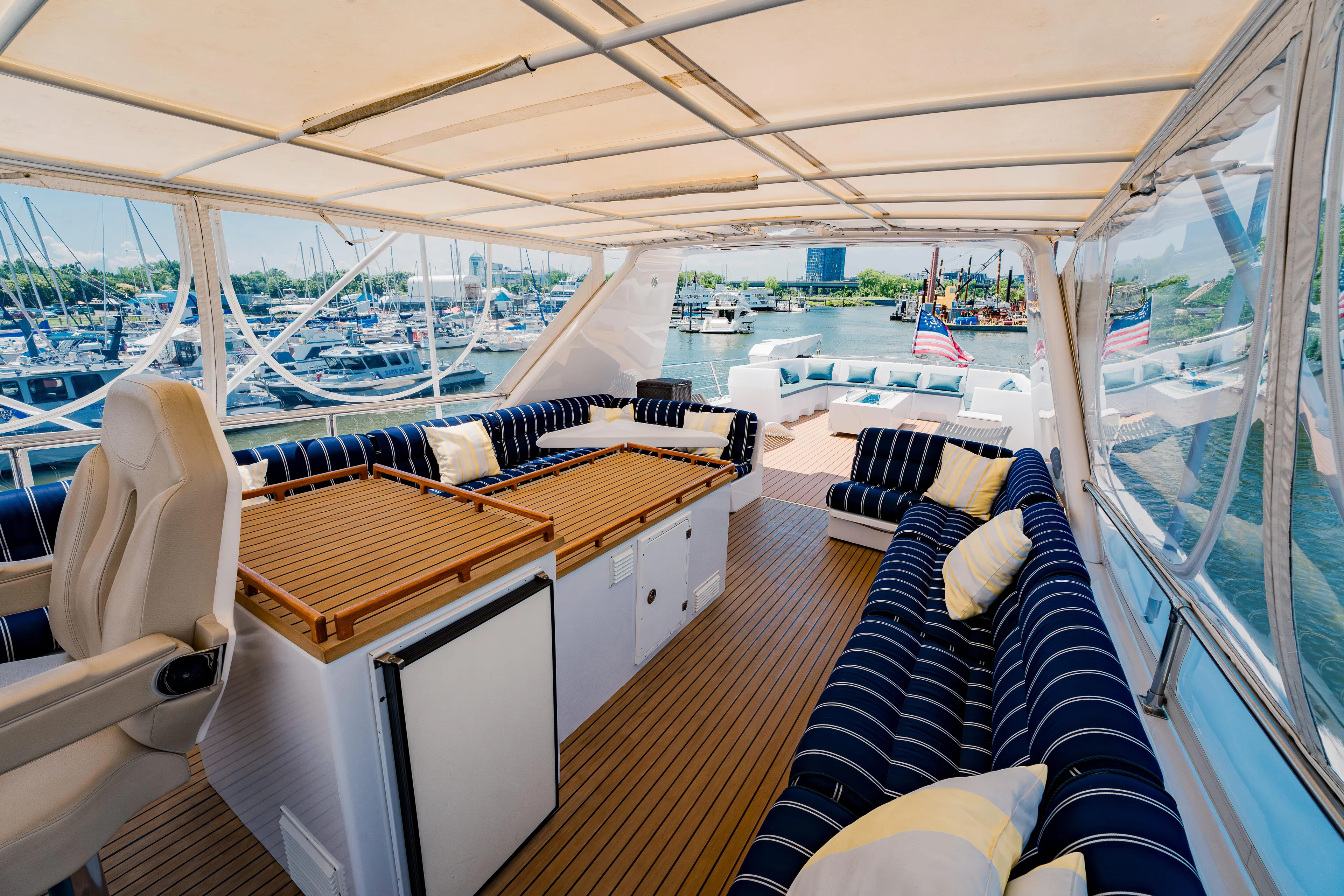 Justine Yacht Photos Pics Luxurious 1987 Guy Couach 97 yacht deck with striped seating and marina view.