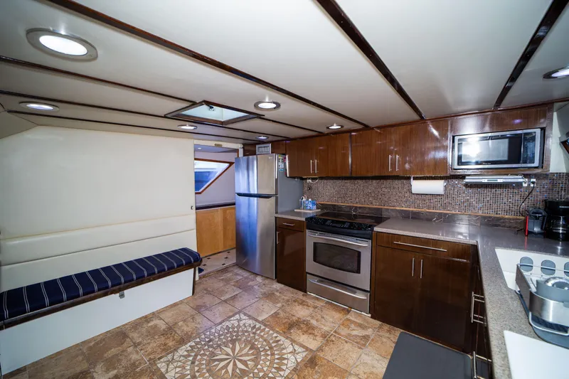 Justine Yacht Photos Pics Interior of 1987 Guy Couach 97 yacht with modern kitchen and seating area.