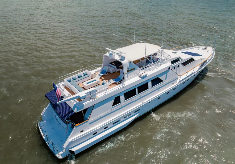 Justine Yacht Photos Pics Luxury 1987 Guy Couach 97 yacht cruising on open water, aerial view.