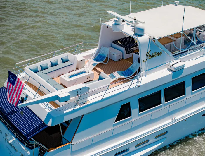Justine Yacht Photos Pics Luxurious 1987 Guy Couach 97 yacht with spacious deck and seating, cruising on open water.