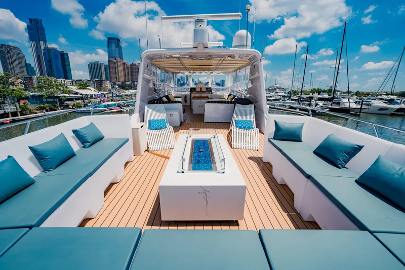 Justine Yacht Photos Pics Luxurious 1987 Guy Couach 97 yacht with spacious deck seating and marina view.