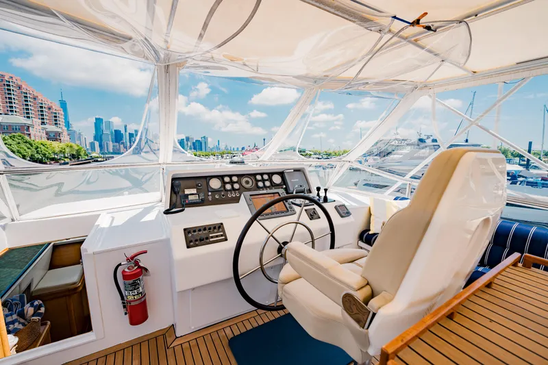 Justine Yacht Photos Pics Helm of 1987 Guy Couach 97 yacht with city skyline view.