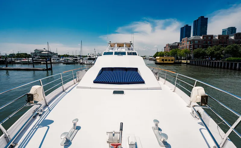 Justine Yacht Photos Pics Luxurious 1987 Guy Couach 97 yacht docked in a scenic marina with city skyline.