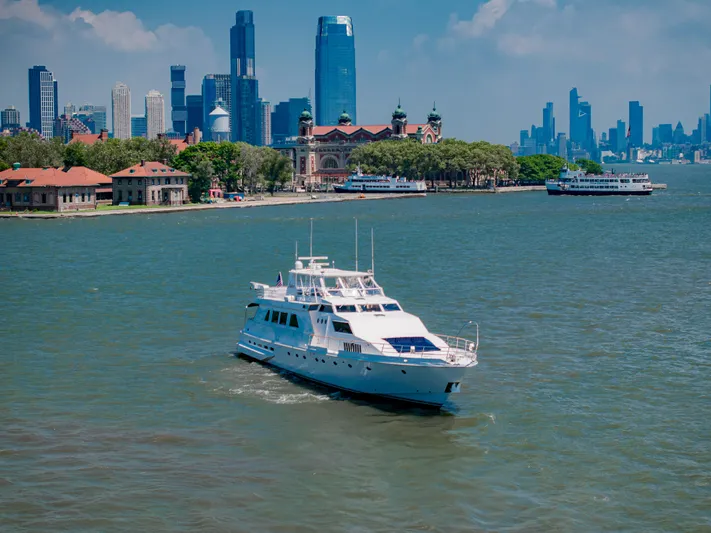 Justine Yacht Photos Pics Luxury yacht Guy Couach 97 (1987) cruising near a city skyline and waterfront.