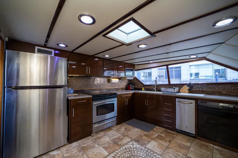 Justine Yacht Photos Pics Luxurious kitchen interior on 1987 Guy Couach 97 yacht, featuring modern appliances and sleek design.