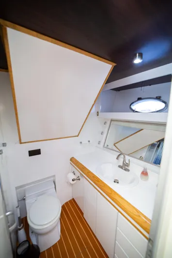 Justine Yacht Photos Pics Luxurious bathroom in 1987 Guy Couach 97 yacht with modern fixtures and wooden accents.