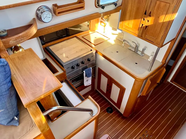  Yacht Photos Pics 1998 Cabo Rico Northeast 400 yacht interior with wooden cabinetry and compact kitchen area.