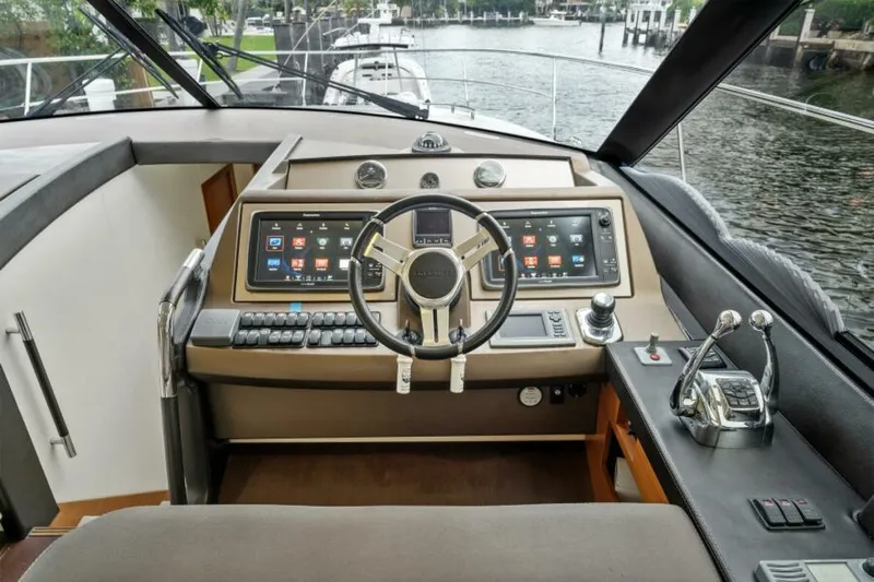Never Enough Yacht Photos Pics Cockpit of 2013 Prestige 550 Flybridge yacht with modern navigation controls and steering wheel.