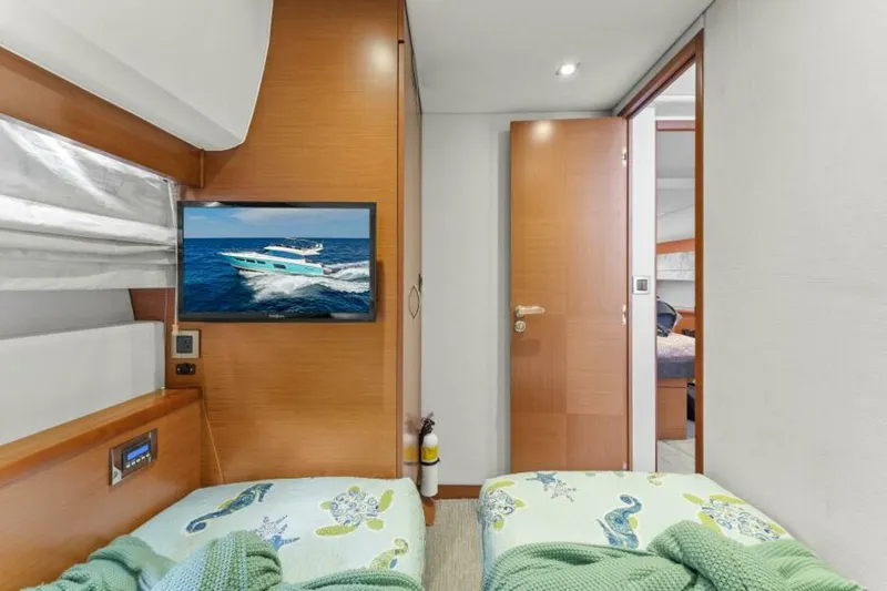 Never Enough Yacht Photos Pics Interior of 2013 Prestige 550 Flybridge yacht with twin beds and wall-mounted TV.