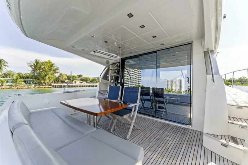Never Enough Yacht Photos Pics Prestige 550 Flybridge 2013 yacht deck with seating, table, and waterfront view.