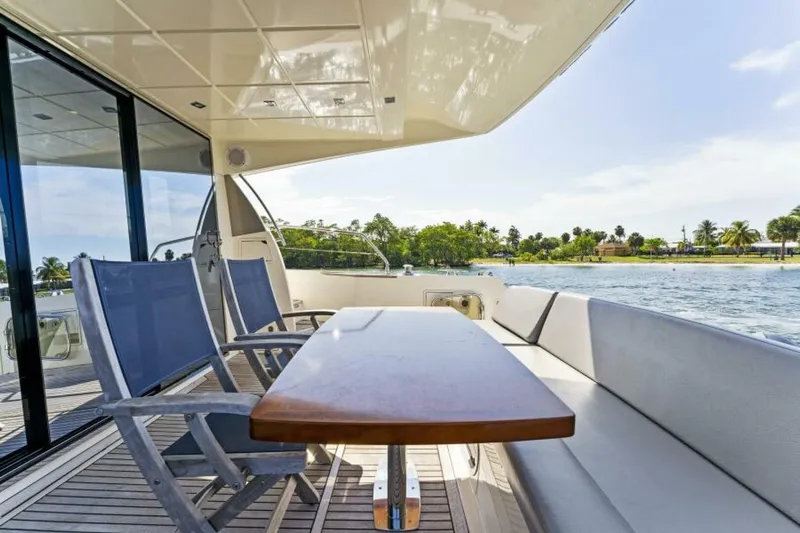 Never Enough Yacht Photos Pics Prestige 550 Flybridge 2013 yacht deck with seating, table, and scenic water view.