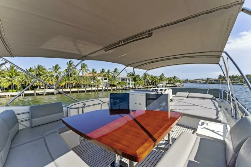 Never Enough Yacht Photos Pics Flybridge of 2013 Prestige 550 yacht with seating, table, and waterfront view.