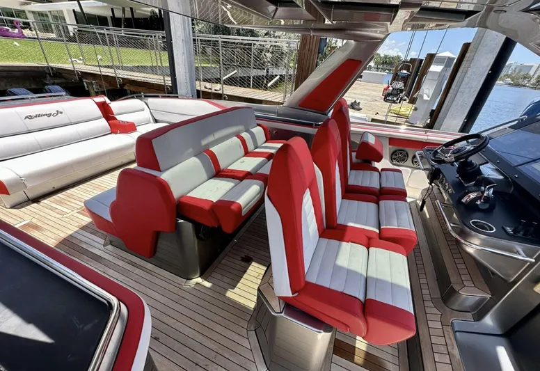  Yacht Photos Pics 2020 Cigarette 59 Tirranna boat interior with red and gray seating, docked by the water.