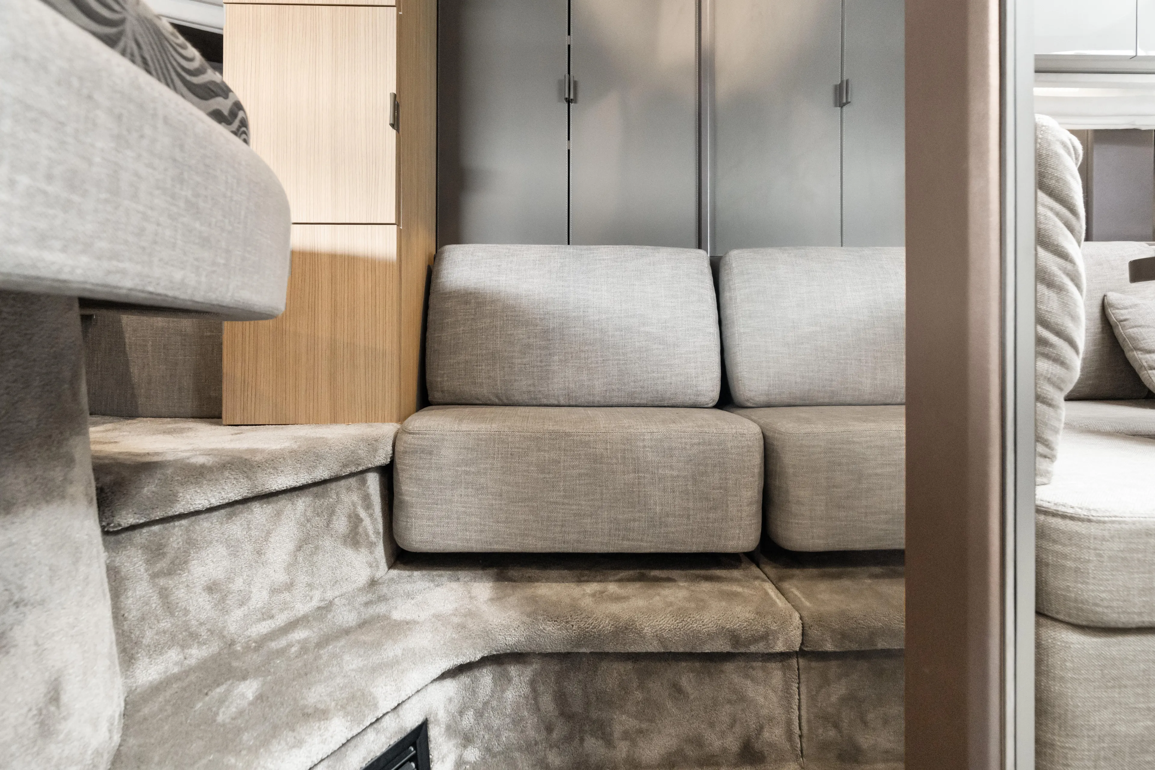  Yacht Photos Pics 2023 Cranchi M44HT yacht interior with modern gray seating and wooden cabinetry.