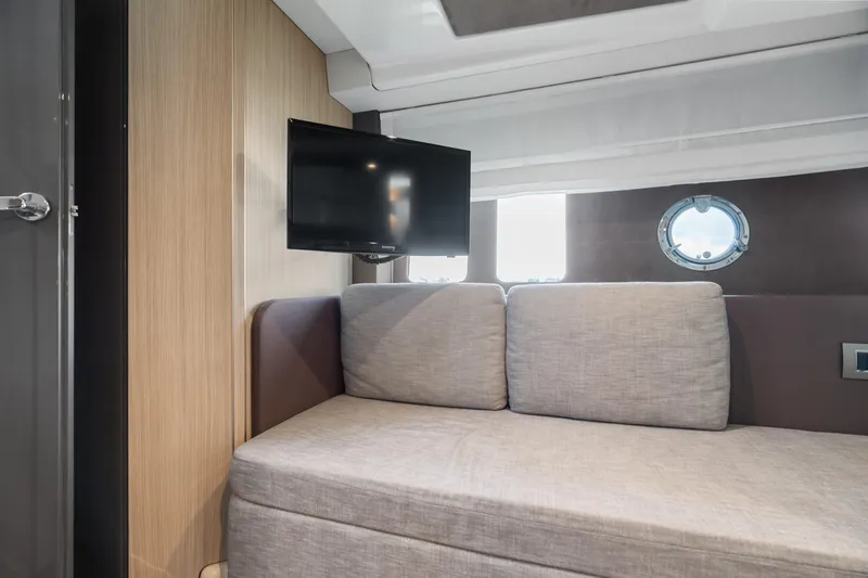  Yacht Photos Pics Interior of 2023 Cranchi M44HT yacht with sofa, TV, and porthole window.