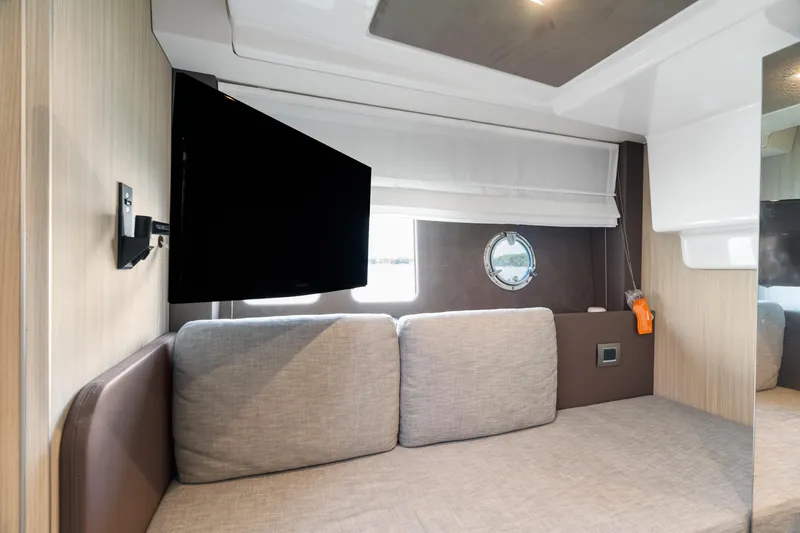  Yacht Photos Pics Interior of 2023 Cranchi M44HT yacht with sofa, TV, and porthole window.