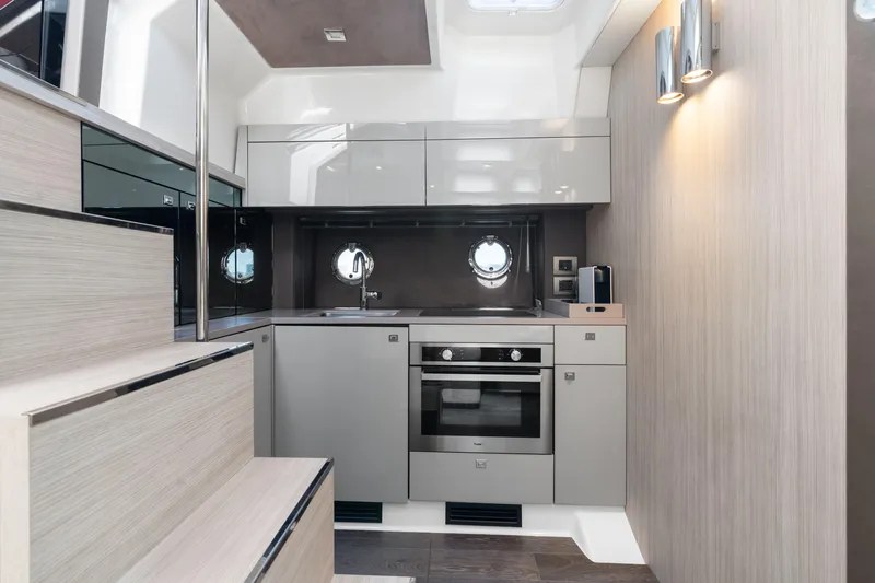  Yacht Photos Pics Modern kitchen interior of 2023 Cranchi M44HT yacht with sleek cabinetry and appliances.