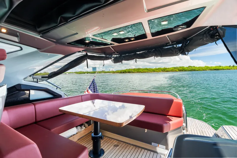  Yacht Photos Pics 2023 Cranchi M44HT yacht interior with seating, table, and water view.