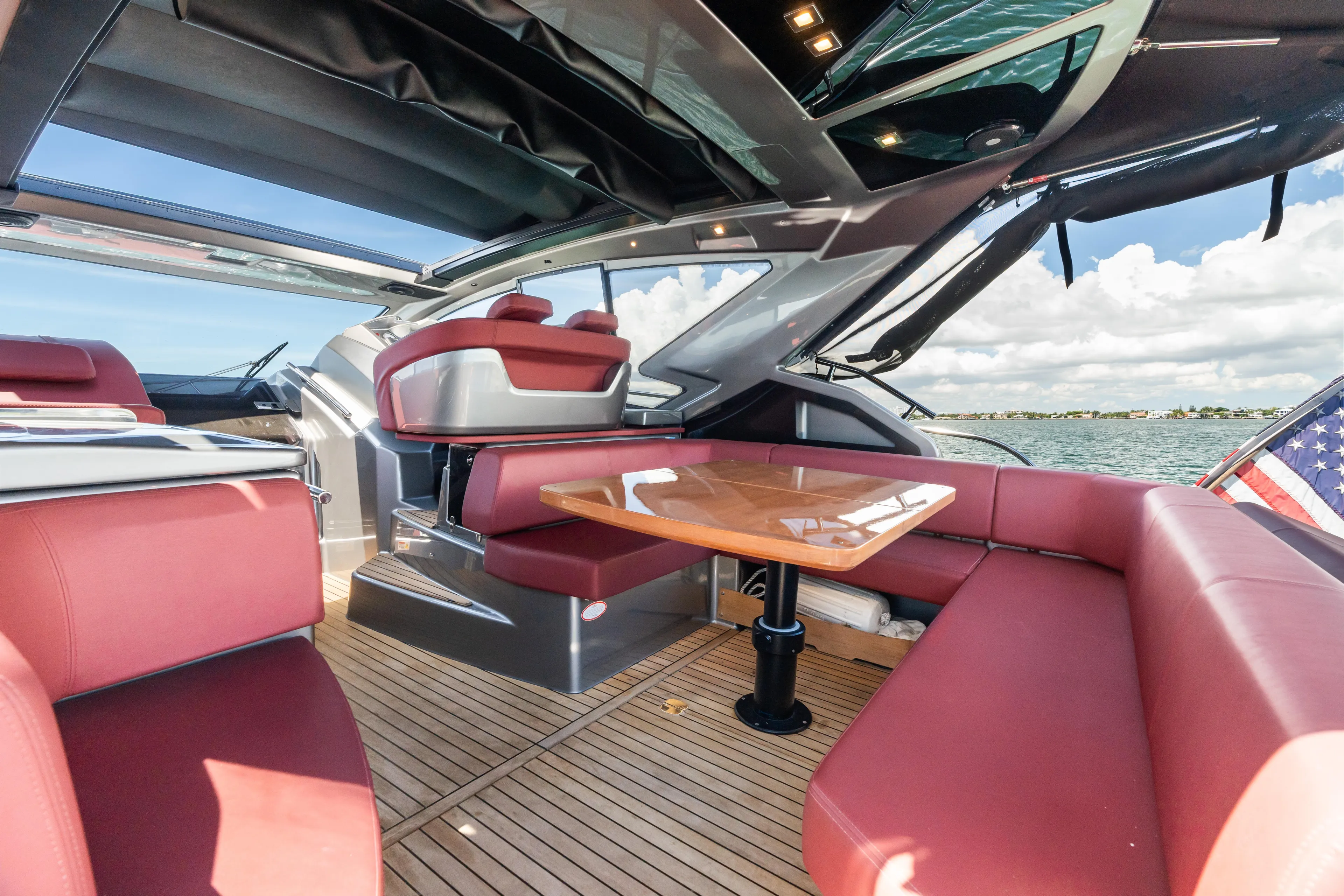  Yacht Photos Pics Luxurious 2023 Cranchi M44HT yacht interior with red seating and wooden table.
