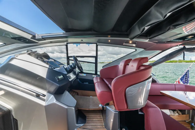 Yacht Photos Pics 2023 Cranchi M44HT yacht interior with red seating and modern helm, overlooking water.