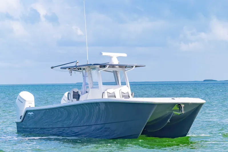  Yacht Photos Pics 2023 Invincible 35 Catamaran on calm ocean waters under a clear sky.