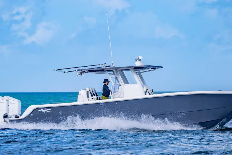  Yacht Photos Pics 2023 Invincible 35 Catamaran cruising on open water under clear blue skies.